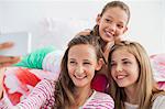 Three girls taking a picture of themselves with a mobile phone at a slumber party