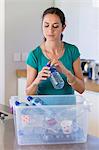 Woman putting a bottle in a recycling bin