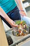 Woman throwing garbage into a dustbin