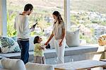 Couple standing in a living room with their daughter