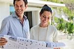 Couple holding a blueprint and smiling