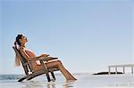 Beautiful woman sitting on a chair on the beach