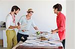 Friends arranging food on a dining table