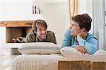 Two male friends smiling on the bed