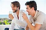 Two male friends enjoying white wine in outdoor