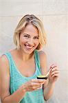 Portrait of a smiling woman eating avocado