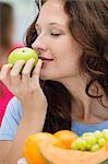 Close-up of a woman smelling a green apple