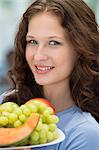 Smiling woman holding a plate of fruits