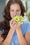 Close-up of a woman smelling grapes