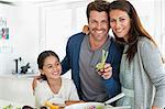 Couple with their daughter enjoying in the kitchen