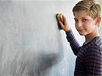 Boy cleaning blackboard with a duster in a classroom