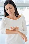 Woman applying ointment on her arm