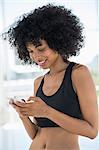 Smiling woman text messaging on a mobile phone