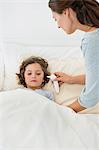 Woman checking fever of her son with a thermometer