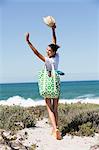 Happy woman carrying a bag on the beach