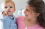 Girl with her brother smiling at home