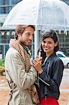 Smiling couple under an umbrella