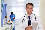 Doctor carrying tablet computer in hospital