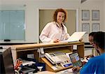 Hospital staff talking at front desk