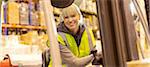 Worker operating forklift in warehouse