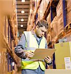 Worker reading clipboard in warehouse