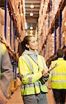 Worker writing on clipboard in warehouse