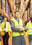 Worker writing on clipboard in warehouse