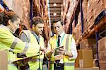 Businessman and workers talking in warehouse