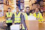 Workers smiling by conveyor belt in warehouse