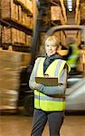 Worker holding clipboard in warehouse