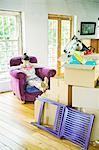 Woman drinking tea with unpacked boxes