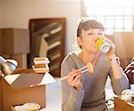 Woman drinking soda and eating sushi in new home