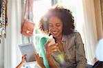 Women using tablet computer and cell phone in bedroom