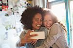 Women taking picture together in bedroom