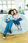 Couple watching television in beanbag chair