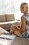 Businesswoman using tablet computer on sofa
