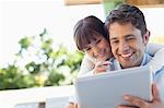 Father and daughter using tablet computer together