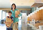 Mother and son holding groceries in kitchen