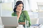 Businesswoman wearing headphones at desk