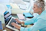 Businesswoman using laptop at desk