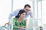 Business people using laptop together at desk