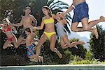 Family jumping into swimming pool