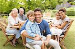 Family smiling at table outdoors