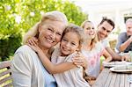 Older woman and granddaughter smiling outdoors