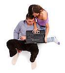 Young couple together, sitting and looking to laptop computer