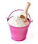 Natural salt and wooden scoop in a bucket on a white.
