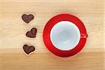 Coffee cup and heart shaped cookies on wooden table. View from above