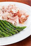 Green asparagus and prosciutto on a plate