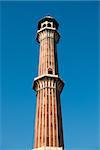 High minaret in Jama Masjid Mosque, Delhi, India with blue sky on background