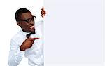 African young man pointing and looking at blank billboard wearing glasses